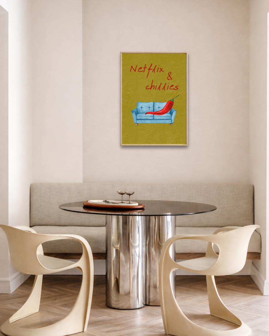 Modern eetkamerinterieur met ronde glazen design tafel, crèmekleurige stoelen en een ingelijste groene Netflix & Chillies fine art poster aan de muur van Bloom Archives.