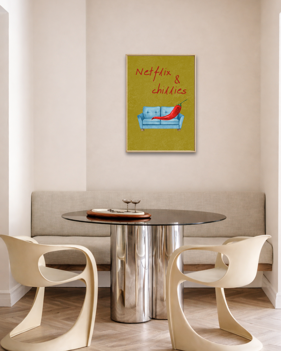 Modern eetkamerinterieur met ronde glazen design tafel, crèmekleurige stoelen en een ingelijste groene Netflix & Chillies fine art poster aan de muur van Bloom Archives.