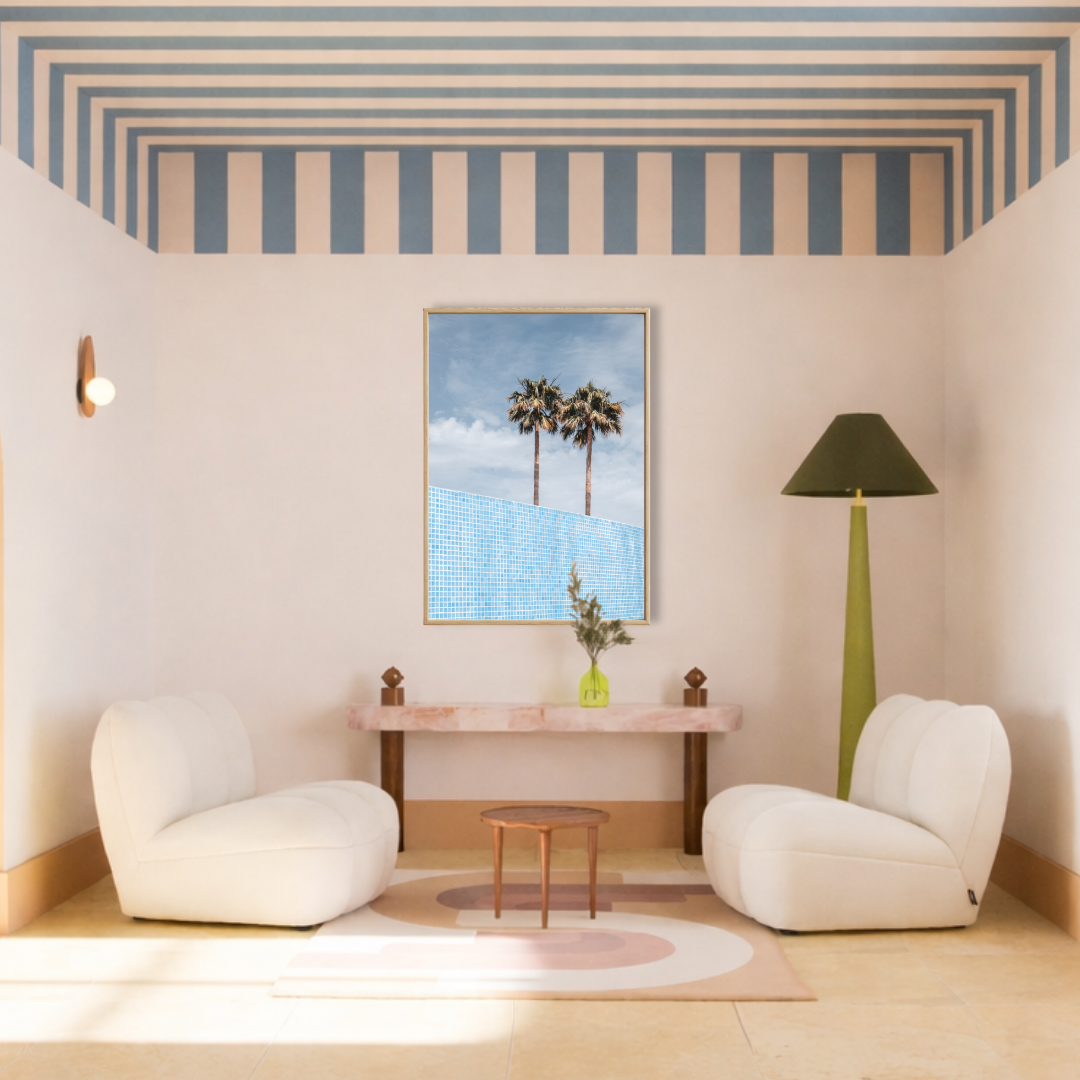 Modern interieur met zachte design fauteuils en een ingelijste Poolside Palms on Film fine art poster met palm bomen en zwembad van Bloom Archives.